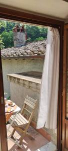 eine Glasschiebetür mit einem Stuhl auf einer Terrasse in der Unterkunft La Casa del Nonno - Tiny House in Reggello