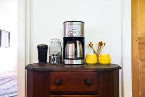 a coffee maker on top of a wooden table at The Waldoboro Inn Room 1 in Waldoboro