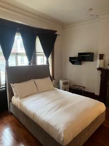 a bedroom with a large bed with blue curtains at Les chambres des Grisons établissement sans contact in Quebec City