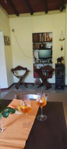 dos copas de vino sentadas en una mesa en una sala de estar en La Casa del Nonno - Tiny House en Reggello
