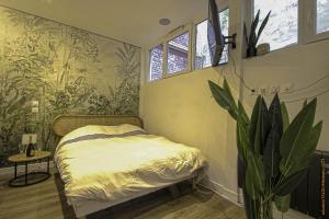 - une chambre avec un lit et une plante dans l'établissement CosyRouen Bali Spa Hamman, à Rouen