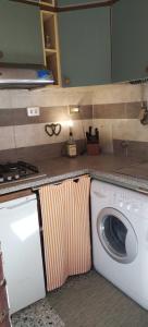 una lavatrice in una cucina con bancone di La Casa del Nonno - Tiny House a Reggello