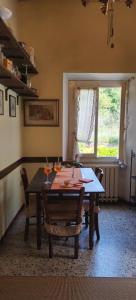 una sala da pranzo con tavolo, sedie e finestra di La Casa del Nonno - Tiny House a Reggello