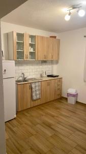 a kitchen with wooden cabinets and a white refrigerator at Stone House in Posušje