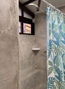 een douche met een douchegordijn in de badkamer bij AYNI in Canoas