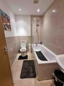 a bathroom with a bath tub and a toilet at Bright and cosy 1 bed flat next to Tower Bridge in London