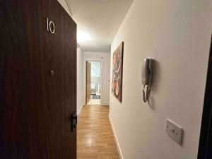 um corredor com uma porta e um telefone na parede em Bright and cosy 1 bed flat next to Tower Bridge em Londres