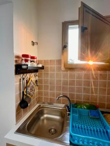 eine Küchenspüle mit einem blauen Korb darauf in der Unterkunft MONOLOCALE LA GROTTA in Capilungo + 23 Fotos