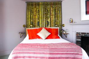 a bedroom with a bed with red pillows and a fireplace at The Waldoboro Inn Room 5 in Waldoboro