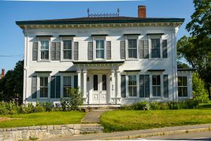 WaldoboroにあるThe Waldoboro Inn Room 5の庭に緑の襖を敷く白い家