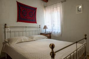 1 dormitorio con cama y ventana con bandera en Villa ONAR, en Kalochorafitis