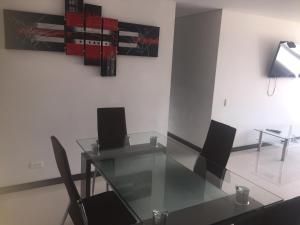 jadalnia ze szklanym stołem i krzesłami w obiekcie Apartamento relajante , exclusivo, moderno e iluminado ,Sabaneta ,Medellín w mieście Sabaneta