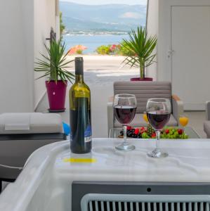 Luxury apartment on the beach في تروغير: زجاجة من النبيذ وكأسين على الطاولة
