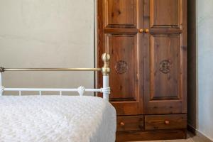 1 dormitorio con 1 cama y armario de madera en Villa ONAR, en Kalochorafitis