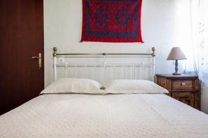 1 dormitorio con cama blanca y manta roja en Villa ONAR, en Kalochorafitis