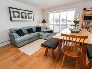 a living room with a couch and a table at Sandbanks in Penzance