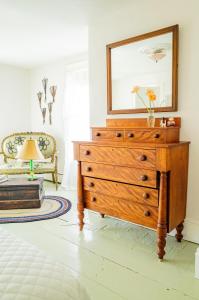 a bedroom with a dresser with a mirror on top at The Waldoboro Inn Room 3 in Waldoboro
