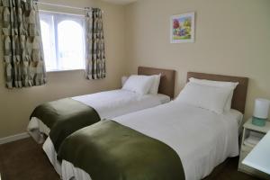 two beds in a small room with a window at Centrally located house on Ring of Kerry in Killorglin
