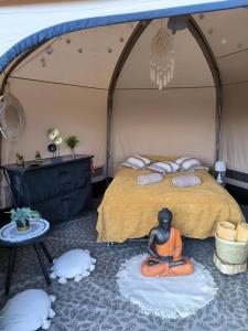 Zimmer mit einem Bett und einem Mönch auf dem Boden in der Unterkunft Glamping Rožnov in Rožnov pod Radhoštěm