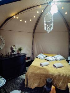a bedroom with a bed in a tent with a chandelier at Glamping Rožnov in Rožnov pod Radhoštěm
