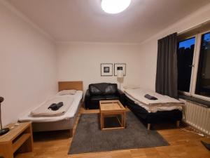 a living room with two beds and a couch at Home Inn BG11 in Stockholm