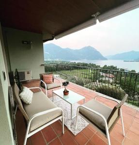 un patio con sillas y una mesa y vistas al agua en Casa CAPONETTI, en Costa Volpino