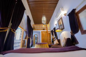 a bedroom with a bed with purple curtains at Riad Sahraui in Fez
