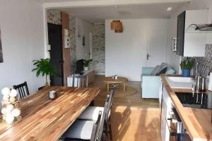 cocina y sala de estar con mesa de comedor de madera en Appartement 4 Chambres en Champigny-sur-Marne