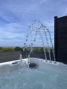 a bath tub filled with water with a fountain at terfyn hall holiday apartment 3 stargazer in Prestatyn