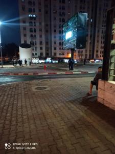 Een man op een bankje in een stad 's nachts bij Ain Naadja Gue De Constantine 