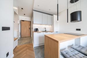 a kitchen with white cabinets and a wooden counter top at Verona House Apartment in Krakow