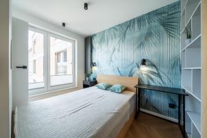 a bedroom with a bed with a blue wall at Verona House Apartment in Krakow