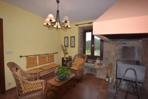 - un salon avec des chaises en osier et une cheminée dans l'établissement Casa Pontenova, à Cee