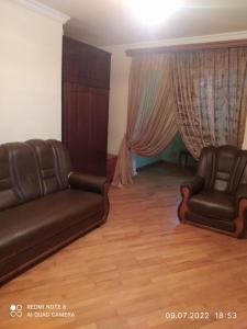 a living room with two leather chairs and a couch at Cozy apartment in Sevan City in Sevan