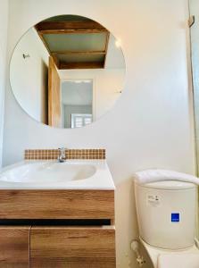 a bathroom with a sink and a mirror over a toilet at Casa ALOHA 152 in Bogotá