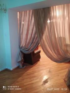 a living room with a curtain and a chair at Cozy apartment in Sevan City in Sevan