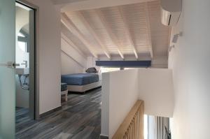 a room with a bed and a hallway with wood floors at Notia Luxury Living in Porto Koufo