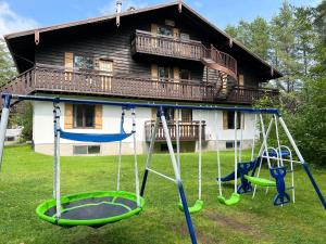 un parque infantil frente a una casa en Chalets Montmorency Mont-Sainte-Anne, en Saint-Férréol-les-Neiges