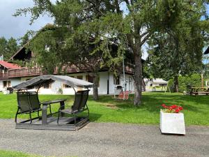 a picnic table with two chairs and an umbrella in front of a house at Chalets Montmorency Mont-Sainte-Anne in Saint-Férréol-les-Neiges +27 photos