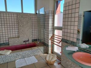 a bathroom with a red tub and a sink at Romantik-Villa LebensART in Reichenfels