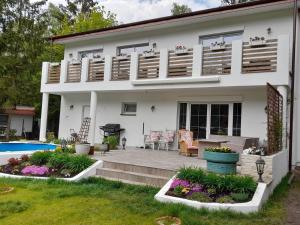 a white house with a patio and a pool at RETRO WILLA in Koronowo