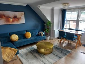 a living room with a blue couch and a table at Luxury Boutique Apartment - Amazing City Location in Cambridge