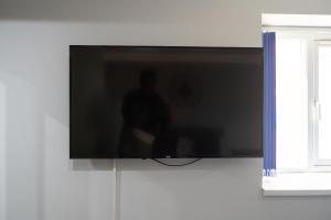a flat screen tv hanging on a wall at Modern Studios with Ensuite, Separate Kitchen, and Prime Location in St Helen Apt 2 in Saint Helens