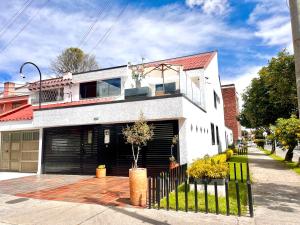 a white house with a black garage at Casa ALOHA 152 in Bogotá