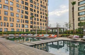 a hotel pool with lounge chairs in front of buildings at Casa Miyana by Kukun in Mexico City