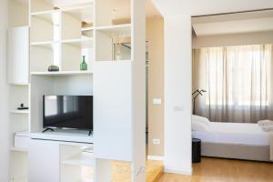 een witte kamer met een tv en een bed bij Casa vacanze Vistamare in Marinella di Sarzana