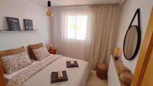 a bedroom with a bed with two towels on it at Heydays Apartment in La Mata