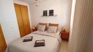 a bedroom with a bed with two towels on it at Heydays Apartment in La Mata