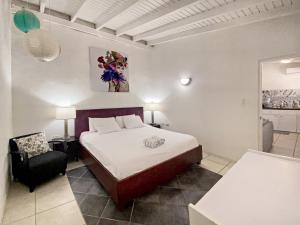 a bedroom with a bed and a chair in it at Casalina Garden 2 blocks to Palm Beach & Kitesurfing school in Palm-Eagle Beach