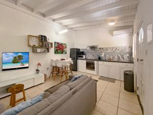 a living room with a couch and a kitchen at Casalina Garden 2 blocks to Palm Beach & Kitesurfing school in Palm-Eagle Beach